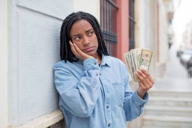 Siyah afro kadın bıkkın, yorgun ve uykulu hissediyor. Dolar banknotları konsepti