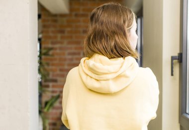 pretty caucasian woman on profile view looking to copy space ahead, thinking, imagining or daydreaming. home interior concept