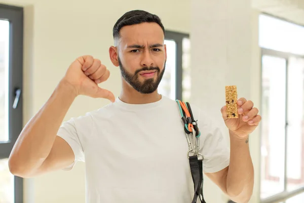 arab handsome man arab man feeling cross,showing thumbs down.  fitness and cereal bar concept