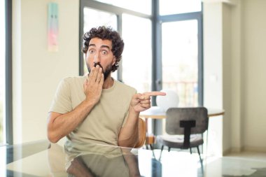 Masasında fotokopi yeri olan genç sakallı adam.