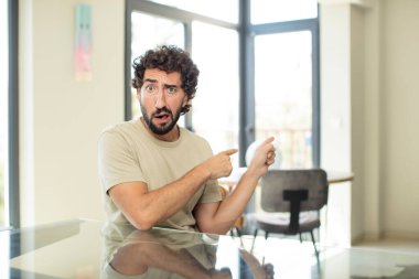 Masasında fotokopi yeri olan genç sakallı adam.