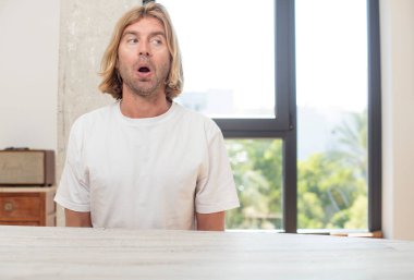 Masasında fotokopi yeri olan genç sarışın yetişkin bir adam.