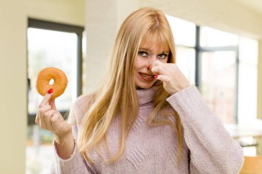 Donutlu genç ve güzel bir kadın. İç mekanda sağlıksız diyet kavramı