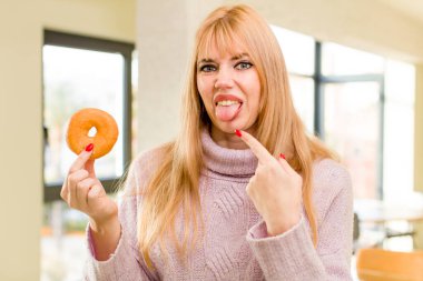 Donutlu genç ve güzel bir kadın. İç mekanda sağlıksız diyet kavramı