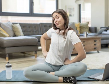 Genç bir kadın yoga yapıyor. Gururlu, kendinden emin, havalı, küstah ve kibirli görünüyor. Başarılı hissediyor.