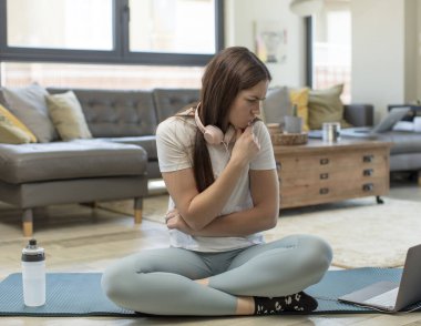 Genç bir kadın yoga yapıyor. Kafası karışık ya da şüpheci. Bir fikre odaklanmış, çok düşünüyor.