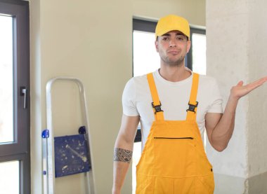 Genç yakışıklı adam omuz silkiyor, kafası karışık ve kararsız. Becerikli adam kavramı