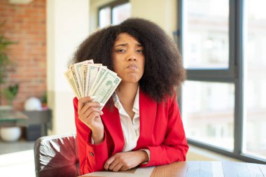 Güzel afro siyah bir kadın üzgün ve ağlayan mutsuz bir bakışla ağlıyordu. Dolar banknotları konsepti