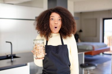 Oldukça afro siyahi bir kadın son derece şok olmuş ve şaşırmış hissediyor. Ev yapımı kurabiye konsepti