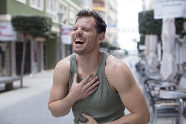 Yakışıklı bir adam komik bir şakaya gülüyor, mutlu ve neşeli hissediyor, eğleniyor.