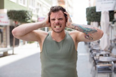 Yakışıklı bir adam stresli, endişeli, endişeli ya da korkmuş, elleri başının üstünde, hata yaptığında panikliyor.