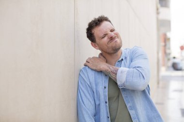 Yakışıklı adam yorgun, stresli, endişeli, hayal kırıklığına uğramış ve depresyonda, sırtı ya da boynu ağrıyan