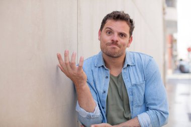 Yakışıklı bir adam kafası karışık ve bilgisiz, şüpheli bir açıklama ya da düşünceyi merak ediyor.