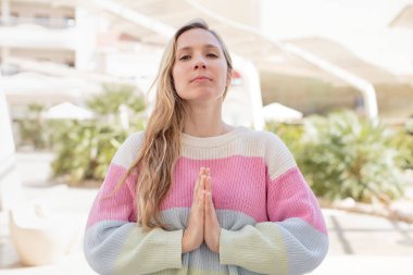 Güzel bir kadın endişeli, umutlu ve dindar, sadık bir şekilde avuç içiyle dua ediyor, af diliyor.