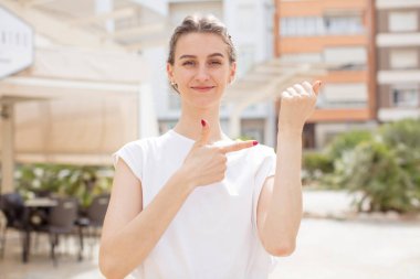 Güzel bir kadın sabırsız ve kızgın görünüyor, saati gösteriyor, dakiklik istiyor, zamanında gelmek istiyor.