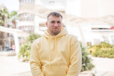 Yakışıklı adam merak ediyor, mutlu düşünceler ve fikirler düşünüyor, hayal kuruyor, kenarda yer arıyor.