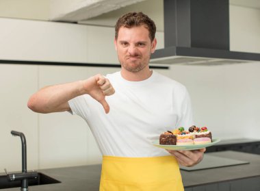 Çapraz hissetmek, baş parmakları aşağı göstermek. Ev yapımı kek konsepti