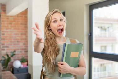 Mutlu bir şekilde gülümsemek ve bir konsept sunmak veya göstermek. Üniversite öğrencisi konsepti