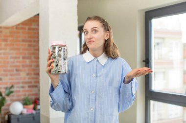 Omuz silkmek, kafası karışık ve kararsız hissetmek. Dolar banknotları konsepti