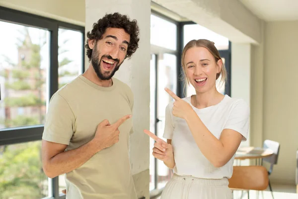 Young Adult Couple Smiling Cheerfully Pointing Copy Space Palm Side — Stock Photo, Image