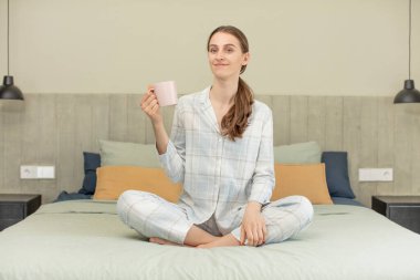 Mutlu ve kendinden emin bir ifadeyle gülümsüyor. yatak zamanı konsepti