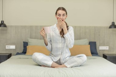 Ağzını eliyle kapatmış ve şok olmuş ya da şaşırmış bir ifade. yatak zamanı konsepti