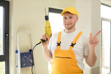 Neşeli bir şekilde gülümsüyor, mutlu hissediyor ve bir tarafı işaret ediyor. Becerikli adam kavramı