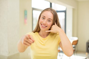 Güzel sarışın kadın neşeyle gülümsüyor ve kamerayı işaret ediyor. Sonra seni arıyor, telefonla konuşuyor.