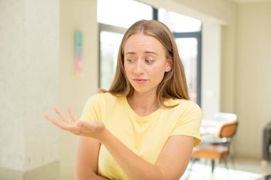 Güzel sarışın kadın, kafası karışık ve habersiz, şüpheli bir açıklama ya da düşünceyi merak ediyor.