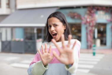 Tatlı İspanyol kadın korkmuş, geri çekiliyor ve korku ve panik içinde bağırıyor, bir kabusa tepki veriyor.