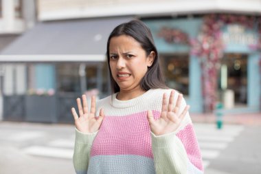 Güzel İspanyol bir kadın tiksinmiş ve rahatsız olmuş hissediyor, dilini dışarı çıkarıyor, iğrenç ve tiksindirici şeylerden hoşlanmıyor.