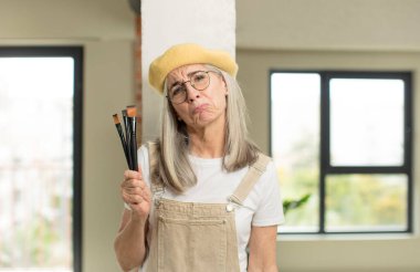 Güzel, yaşlı bir kadın üzgün ve mızmızlanıyor. Mutsuz bir bakışı var ve ağlıyor. sanatçı ressam konsepti