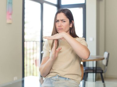 Genç ve güzel bir kadın ciddi, sert, hoşnutsuz ve kızgın görünüyor.