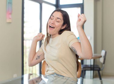Genç, güzel bir kadın gülümsüyor, kendinden emin, başarılı ve mutlu hissediyor, fotokopi alanında fikir veya konsept gösteriyor.