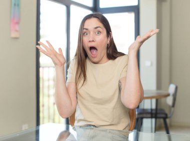 Genç ve güzel bir kadın şok olmuş ya da şaşırmış görünüyor, ağzı açık bir şekilde 