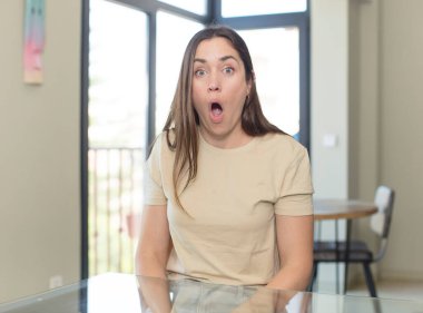 Genç, güzel bir kadın mutlu, şaşırmış ve gururlu hissediyor. Heyecanlı ve şaşkın bir bakışla kendini işaret ediyor.