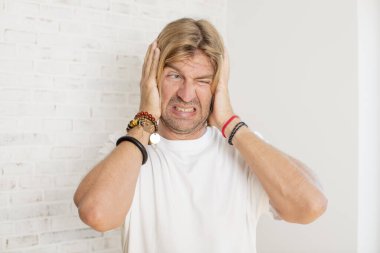 Genç sarışın yetişkin bir adam hayal kırıklığına uğramış ve sıkılmış hissediyor, başarısızlıktan bıkmış ve bıkmış, sıkıcı işlerden bıkmış,