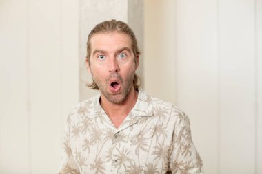 Genç sarışın yetişkin bir adam şok olmuş ya da şaşırmış görünüyor, ağzı açık bir şekilde 