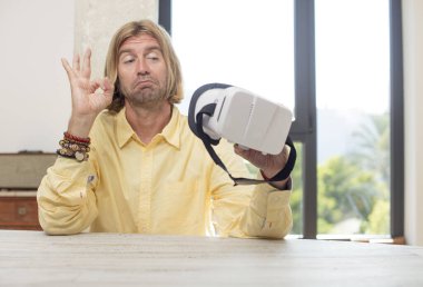 Genç, beyaz bir adam kendini mutlu hissediyor ve iyi bir jestle onaylıyor. sanal gözlük konsepti