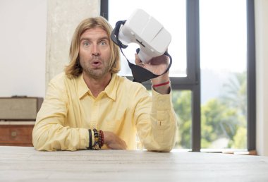 Genç, beyaz bir adam son derece şaşırmış ve şok olmuş hissediyor. sanal gözlük konsepti