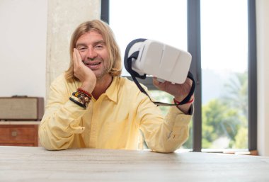 Genç, beyaz bir adam kendini mutlu hissediyor ve inanılmaz bir şeye hayret ediyor. sanal gözlük konsepti