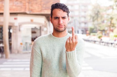 Genç İspanyol bir adam kızgın, sinirli, asi ve agresif hissediyor, orta parmağını sallıyor, karşı koyuyor.
