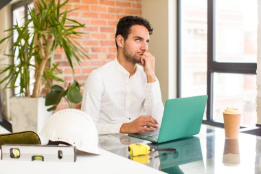 Genç İspanyol bir adam üzgün ve stresli. Kötü bir sürpriz yüzünden üzgün. Olumsuz ve endişeli bir bakışla. mimar konsepti