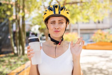 Genç ve güzel bir kadın şans diliyor. bisiklet kaskı konsepti