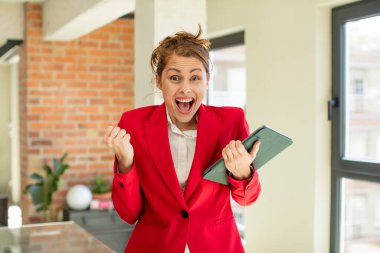 Genç ve güzel bir kadın şokta, gülüyor ve başarıyı kutluyor. Dokunmatik ekran konsepti