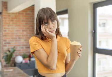 Genç ve güzel bir kadın sıkıcı, bıkkın ve uykulu hissediyor. kahve konseptini kaldır.