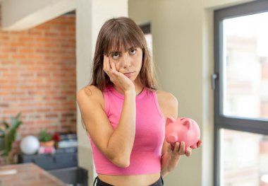 Genç ve güzel bir kadın sıkıcı bir domuz kumbarası konseptinden sonra sıkılmış, hayal kırıklığına uğramış ve uykulu hissediyor.