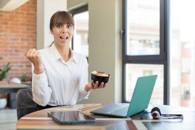 Genç ve güzel bir kadın şokta, gülüyor ve başarıyı kutluyor. ramen kasesi konsepti