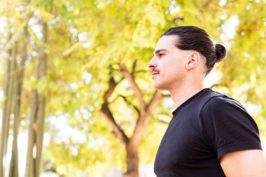 Profil görünümlü genç havalı adam uzayı kopyalamaya çalışıyor, düşünüyor, hayal ediyor ya da hayal kuruyor.