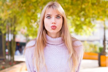 Genç ve güzel bir kadın stresli, mutsuz ve hayal kırıklığına uğramış, alnına dokunuyor ve şiddetli baş ağrısı çekiyor.